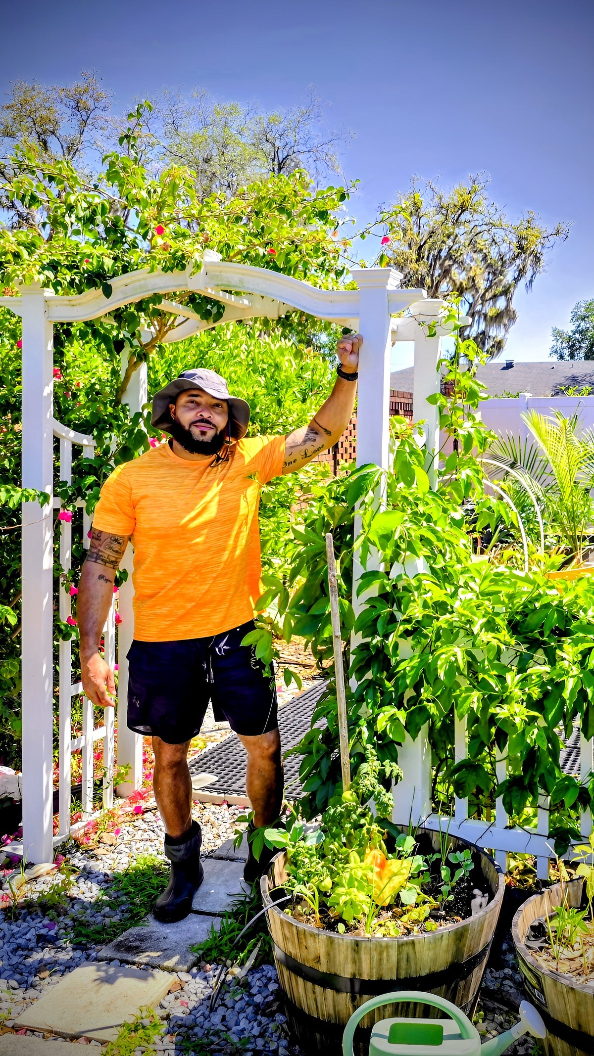 Jermaine Jefferson standing under a garden arbor covered in vines