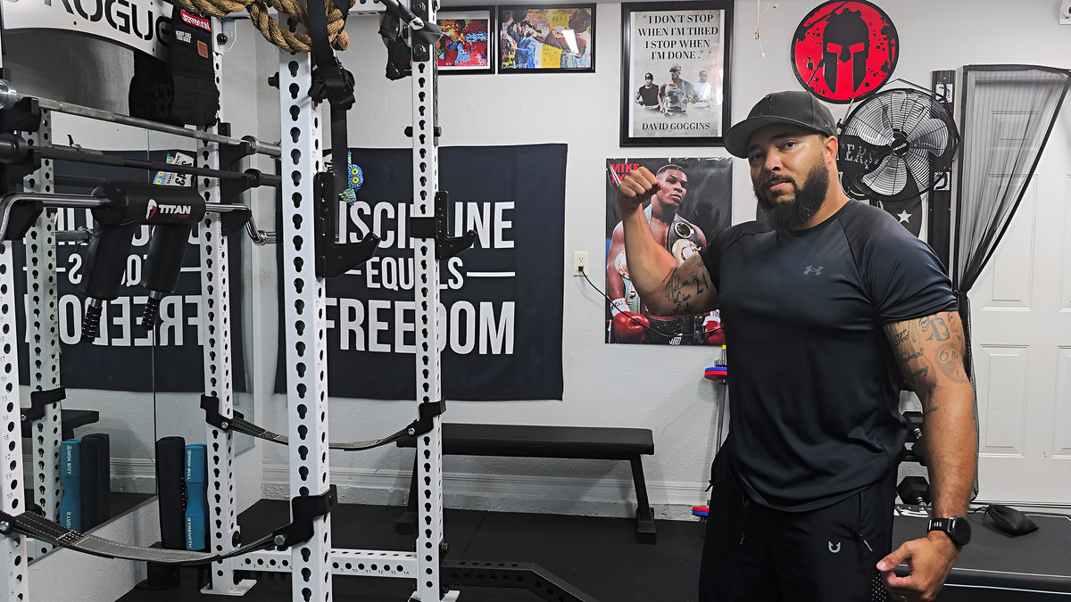 Jermaine Jefferson in his home gym, Discipline Equals Freedom banner behind him