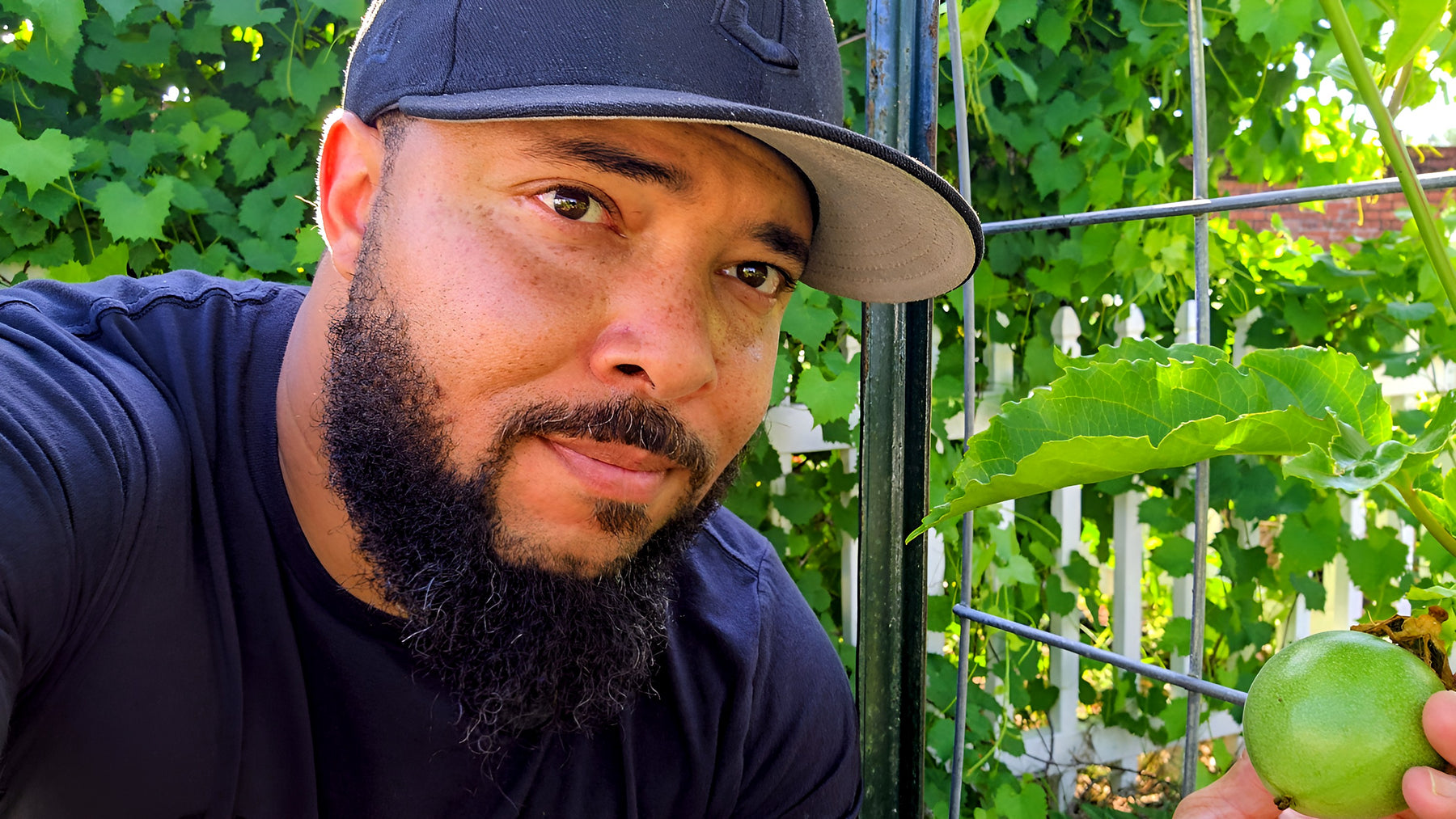 Jermaine Jefferson holding a passion fruit on the vine