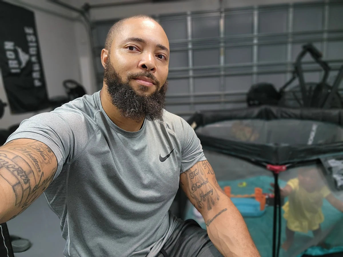 Jermaine in his home gym with one of his children nearby