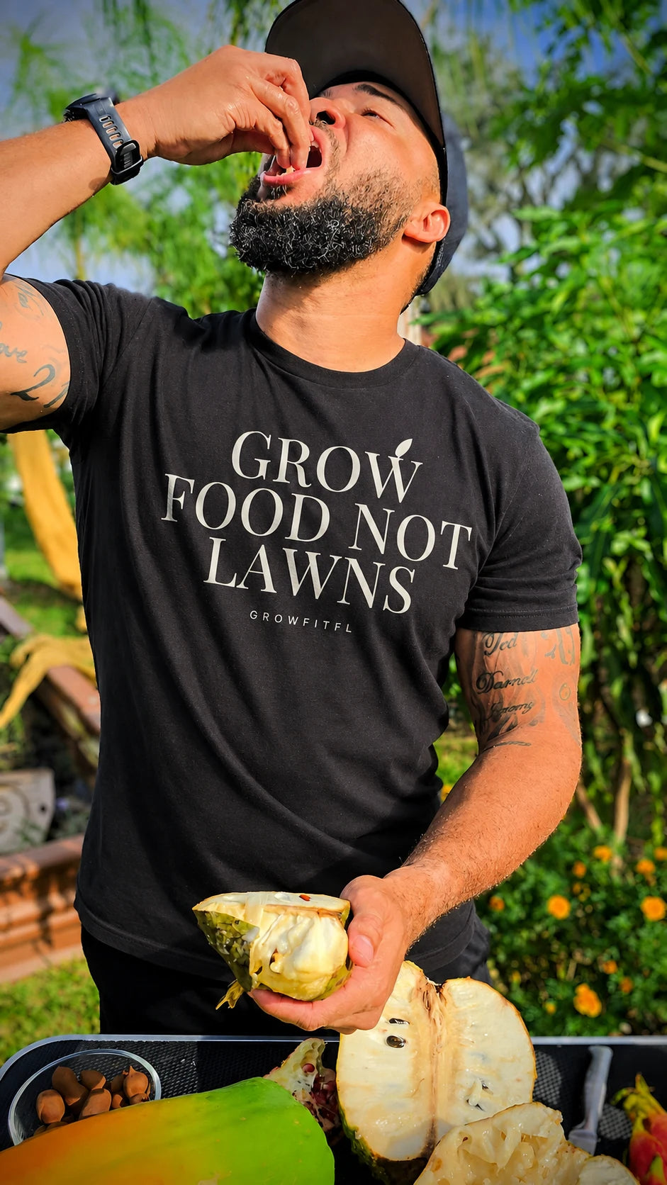 Edited apparel portrait of Jermaine wearing the black Grow Food NOT Lawns tee in his garden